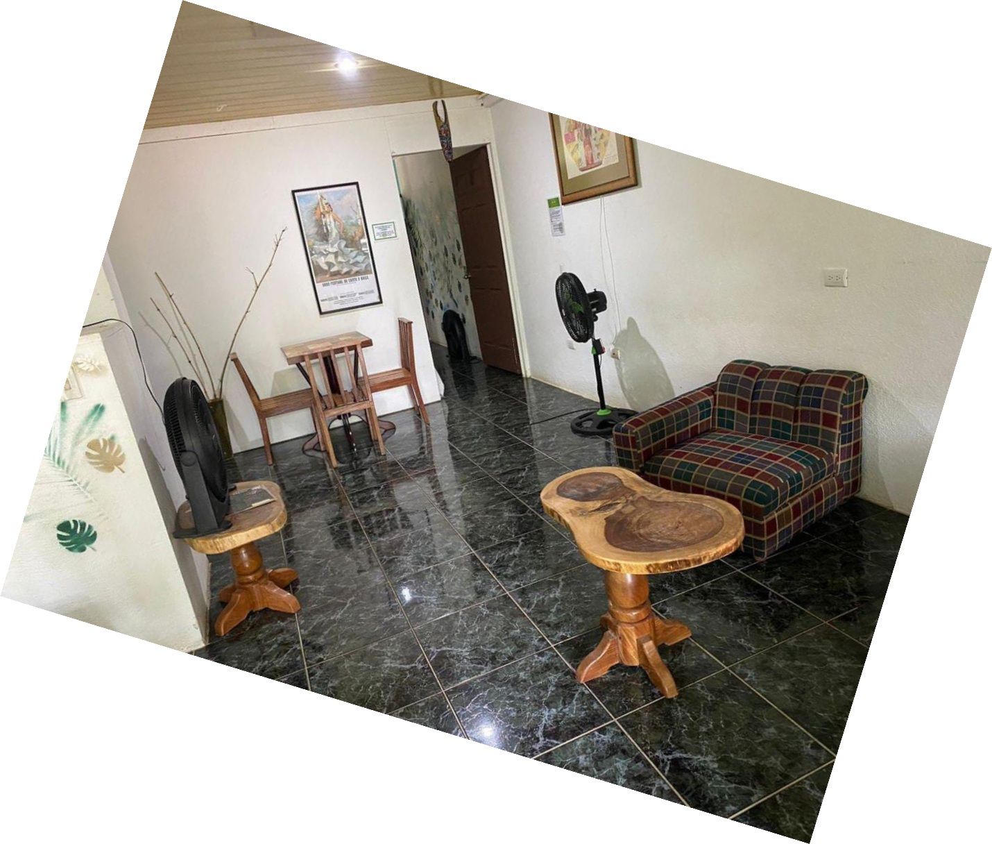 Un salon avec un canapé, une table et un ventilateur.