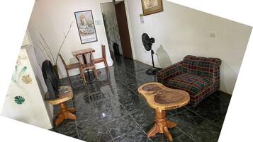 Un salon avec un canapé, une table et un ventilateur.