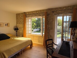 Une chambre à coucher comprenant un lit, une chaise, un bureau et une fenêtre donnant sur l’extérieur.