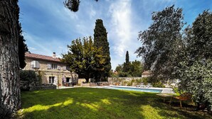 A stone house with a swimming pool, surrounded by a well-maintained lawn and trees. - Villa Hyacinthe (Saint-Étienne-du-Grès)