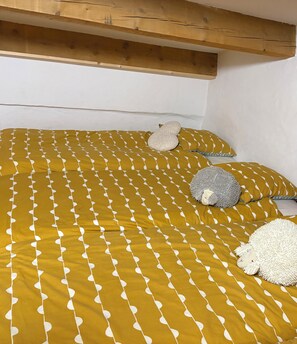 Un lit avec une couvre-lit à motifs et deux coussins décoratifs.
