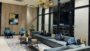 A modern living room with a large sofa set, a coffee table, and a unique chandelier.