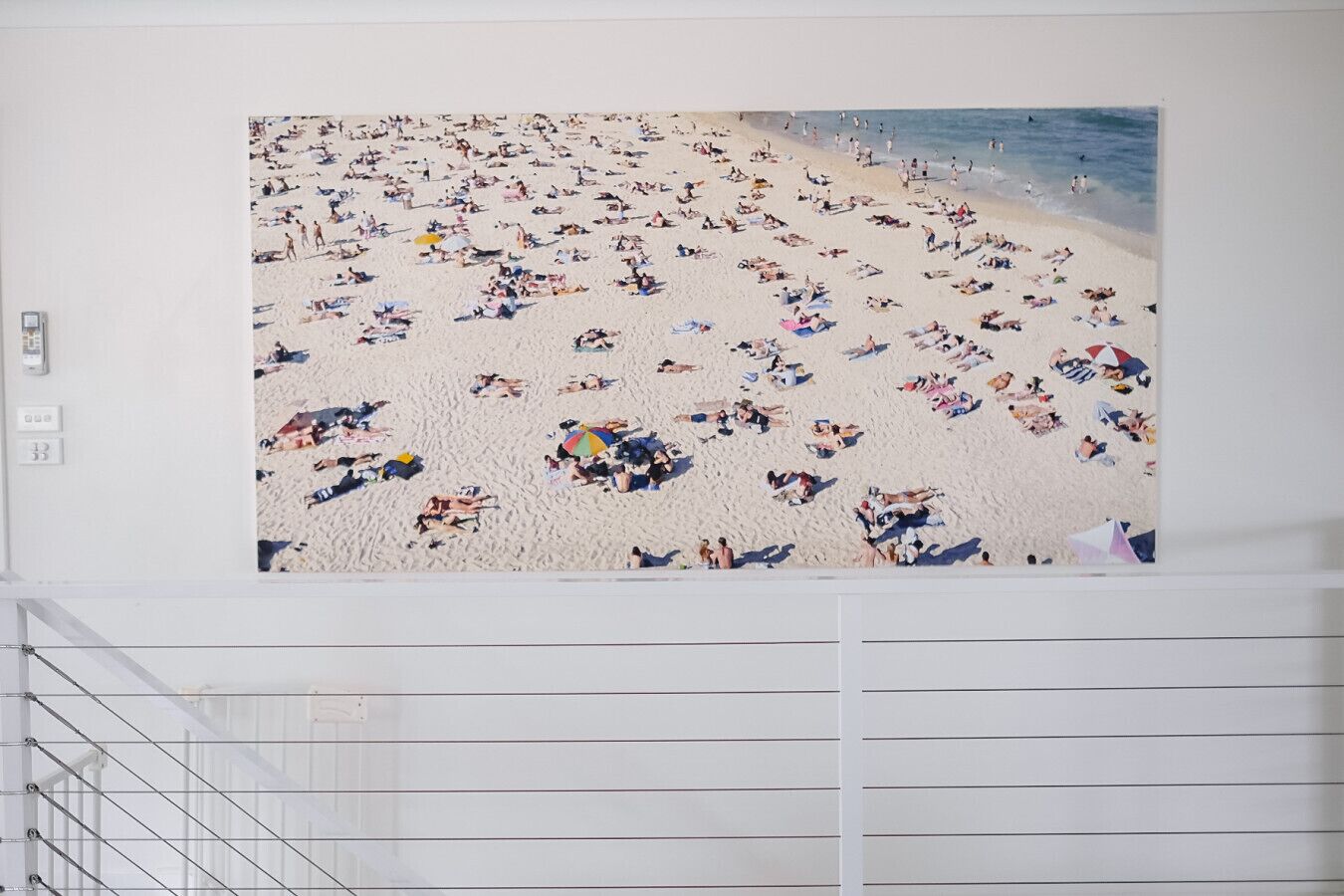 A large wall mural of a crowded beach scene.