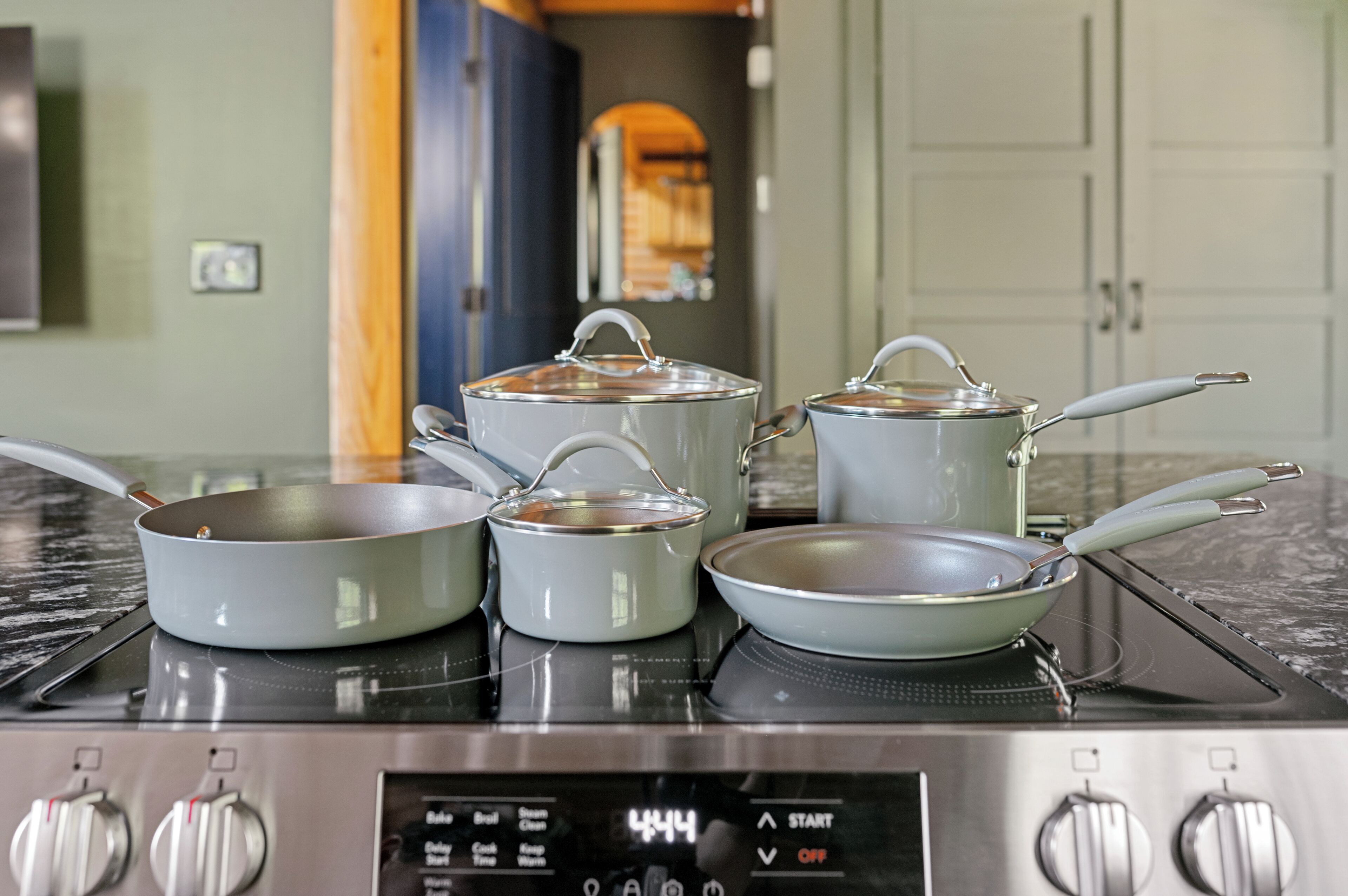 Una cucina con quattro pentole su un piano cottura a induzione.