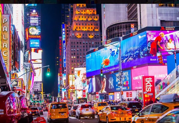 A busy urban street with prominent billboards and advertisements.