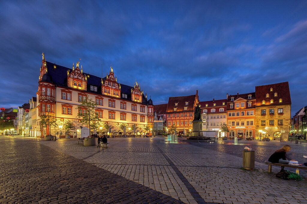 A historic European square with cobblestone pavement and traditional buildings.