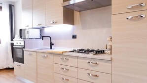 A modern kitchen with a built-in microwave, stove, and oven.