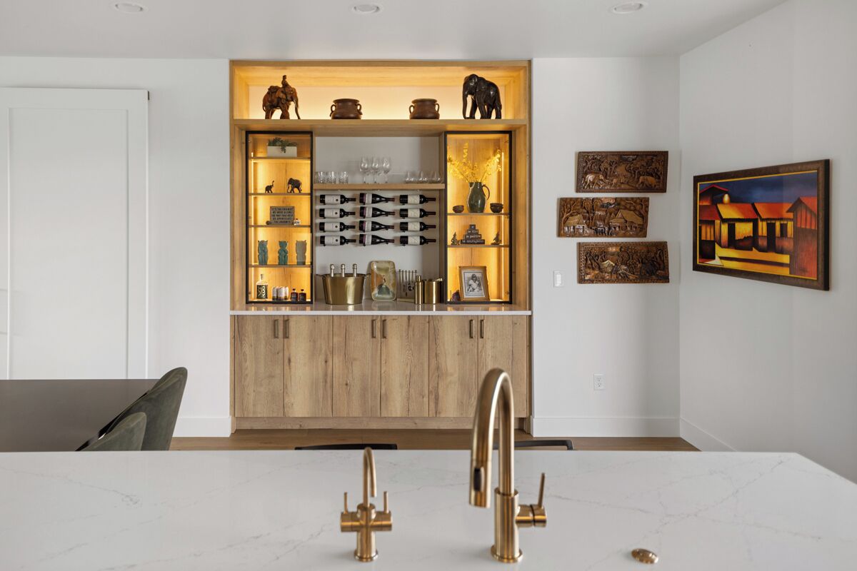 Une cuisine moderne avec des meubles en bois, un plan de travail en marbre et des robinets dorés.