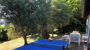 A blue ping pong table in a garden with a brick pathway, surrounded by trees and outdoor furniture. - Provencal-style gîte in a quiet location, private pool, view of the Ardèche in the Drôme. (Albon)