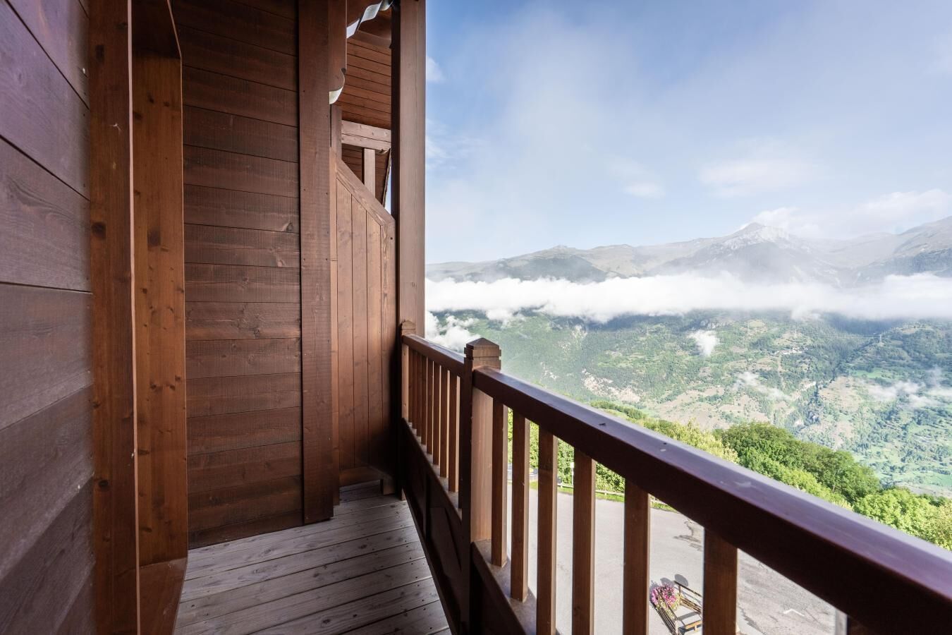 Ein Holzbalkon mit Blick auf eine gebirgige Landschaft.