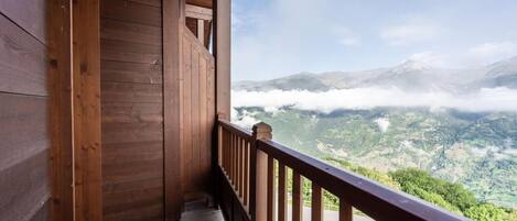 Ein Holzbalkon mit Blick auf eine gebirgige Landschaft.