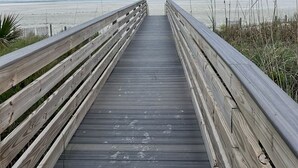 A wooden boardwalk leading to a beach with a clear view of the ocean. - Newly, renovated, modern, OCEANFRONT 2 bedroom, 2 bathroom with 25 ft balcony (Port Orange)