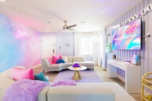 Una sala de estar moderna con un sofá, una mesa de centro y un televisor montado en la pared.