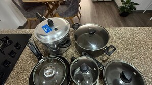 A kitchen with granite countertops, a stove, and various pots and pans. There is a dining area with a table and chairs in the background. - Apartment for 8 guests in the center of Pasto 3 bedrooms 2 bathrooms (Pasto)