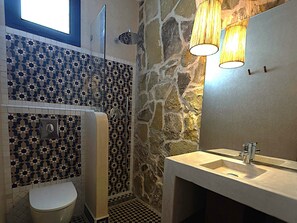 A bathroom with a mosaic tile wall, a stone wall, a toilet, a sink, and a shower. - Palm surf&spa hotel  (Agadir)