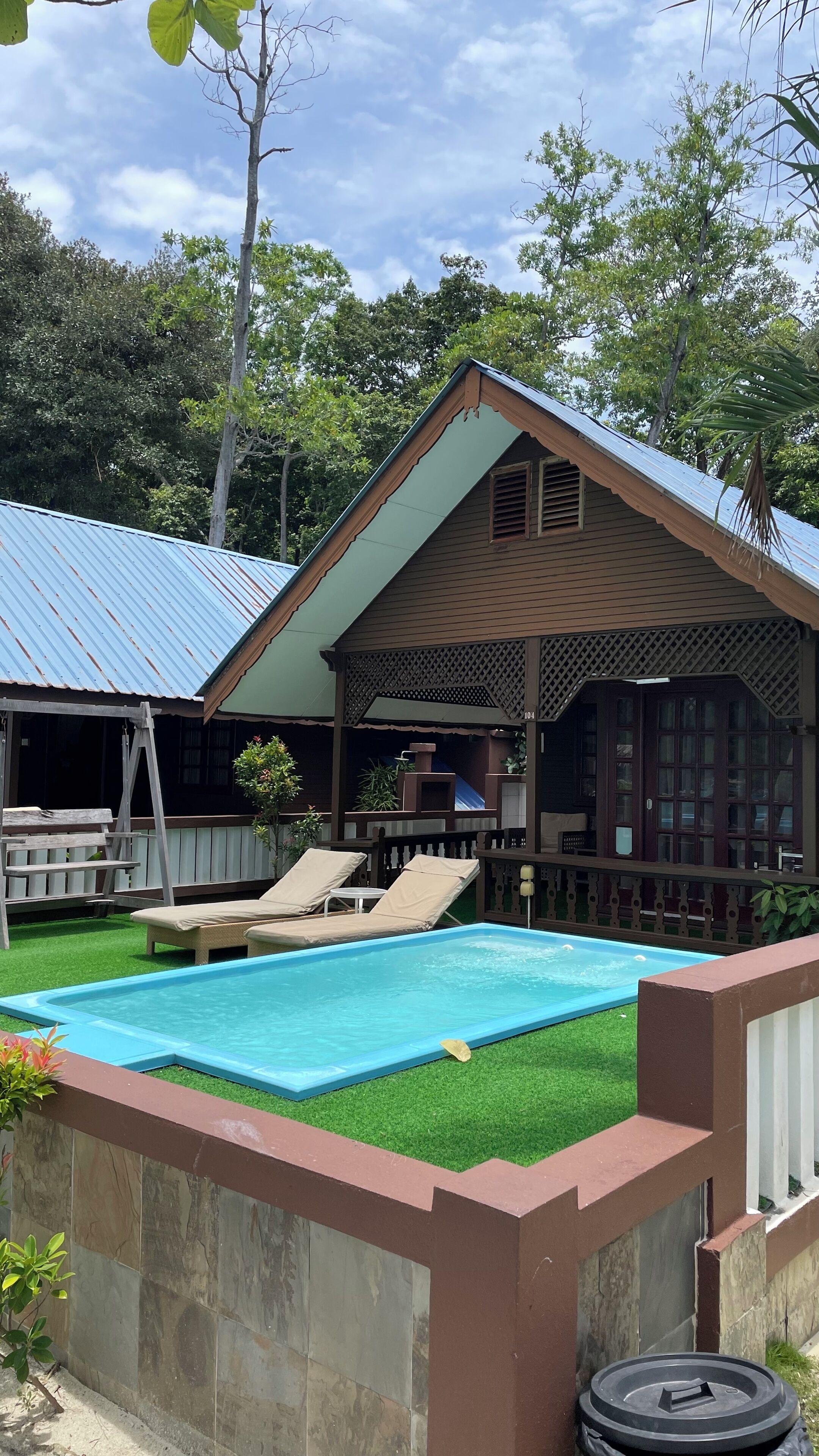 A pool area with lounge chairs and a covered patio.