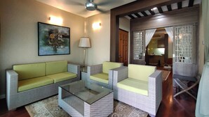 Una sala de estar con un sofá, una mesa de centro, una lámpara y un ventilador de techo.