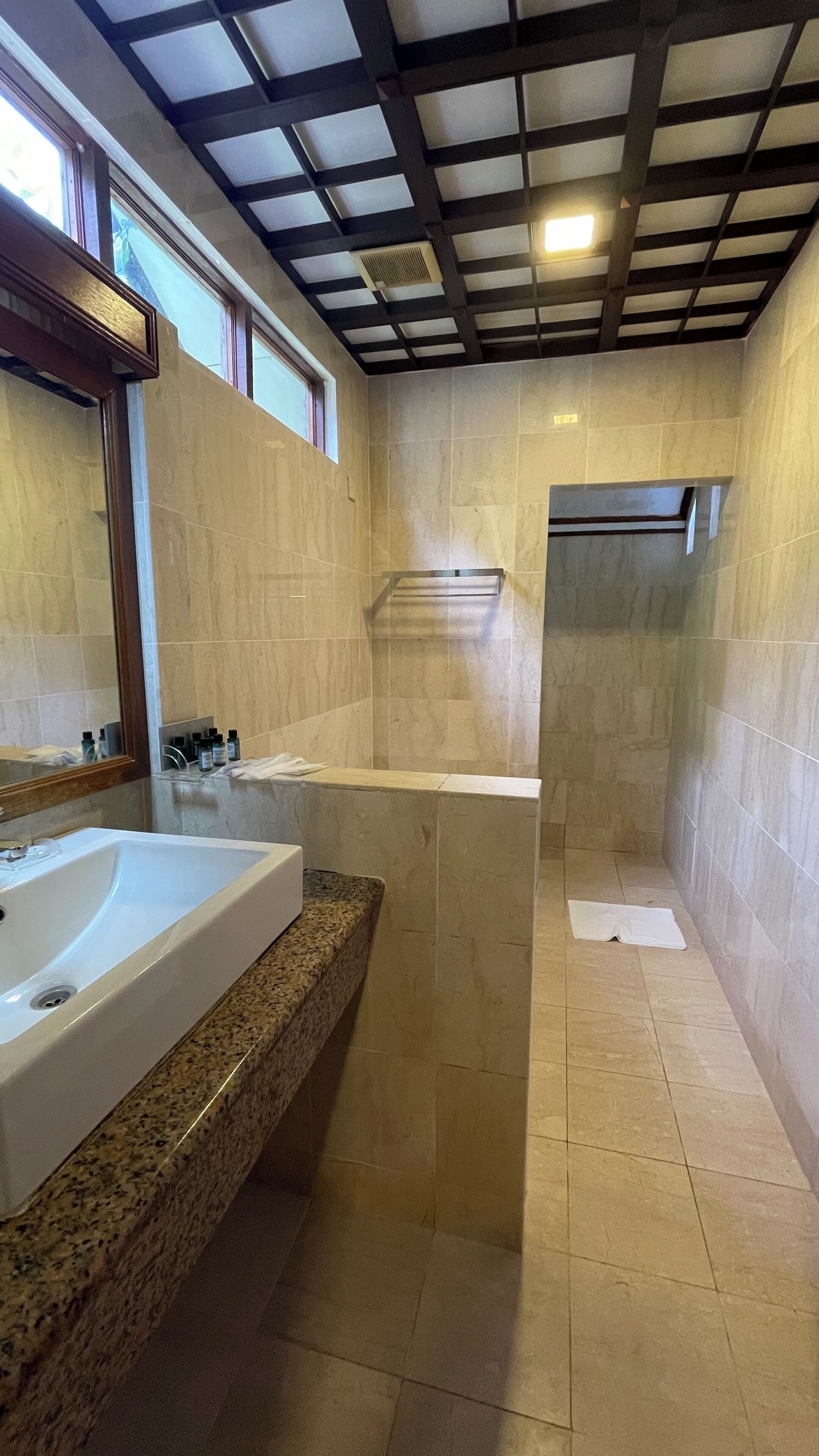 Une salle de bain moderne dotée d’une grande baignoire, d’un espace douche et d’un meuble-lavabo avec un plan de travail en granit.