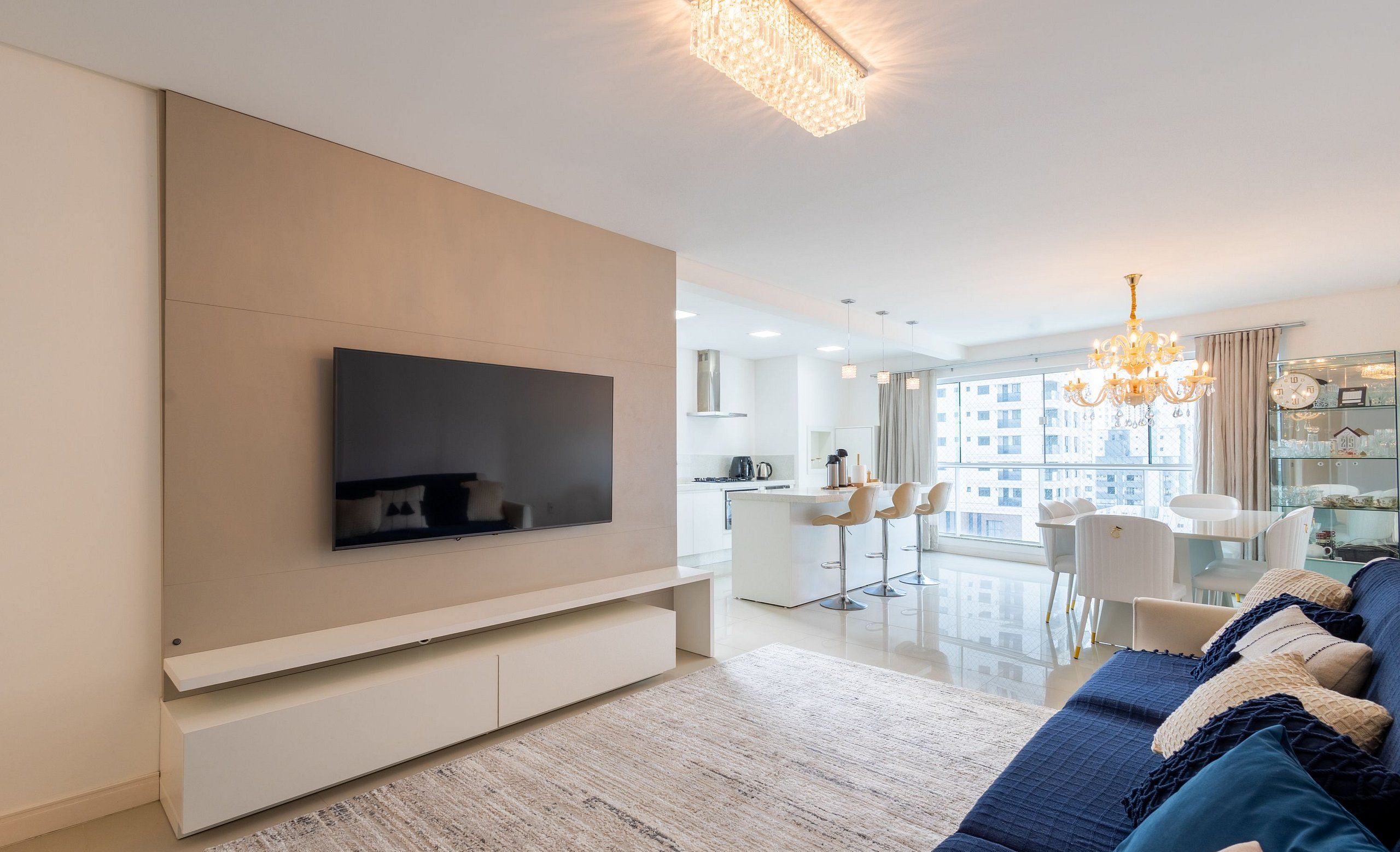 Una sala de estar moderna con televisor de pantalla plana, sofá y candelabro.