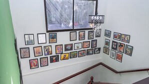 A staircase with a handrail and a wall decorated with framed artworks.