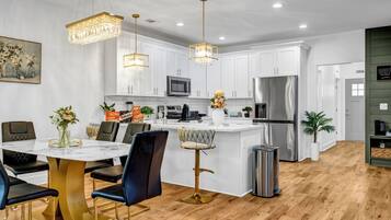A modern kitchen with white cabinets, stainless steel appliances, and a central island.