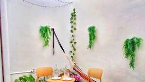 Un pequeño espacio al aire libre con una mesa, sillas y una hamaca.
