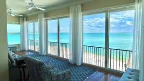A room with a large window overlooking the ocean, a ceiling fan, and a patterned chair. - Gran Palacio-Beachfroont,Pool, Fishing & 360 Views, North Captiva Luxury Escape (Lee County)