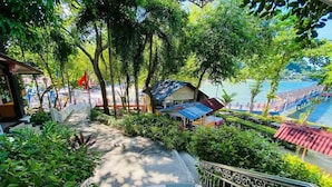 A staircase leading to a covered area with a view of a lake and a boat. - Sharilaa Coral Perhentian Resort (Pulau Perhentian Kecil)
