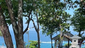 A table set with various dishes including rice, flatbreads, and a bowl of soup, overlooking a scenic ocean view. - Sharilaa Coral Perhentian Resort (Pulau Perhentian Kecil)