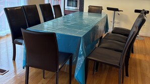 Un comedor con una mesa cubierta por un mantel azul, rodeada de sillas.