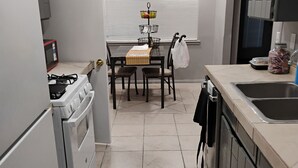 A compact kitchen with a gas stove, a sink, and a dining table with chairs. - 3-bdm home, sunny El Paso near shops, medical, schools, restaurants, & more (El Paso)