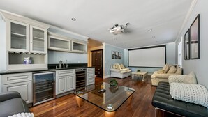 Una sala de estar moderna con una mesa de centro de vidrio, un sofá de cuero negro y un sofá color beige.