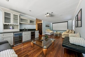 A modern living room with a glass coffee table, a black leather sofa, and a beige sofa. - Tahoe Keys Cozy Mountain Retreat 3BR, 3BA (South Lake Tahoe)