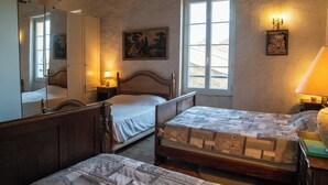Un dormitorio con dos camas, un espejo grande, un cuadro y una ventana.