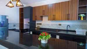 A modern kitchen with wooden cabinets, a black countertop, and a built-in stove.