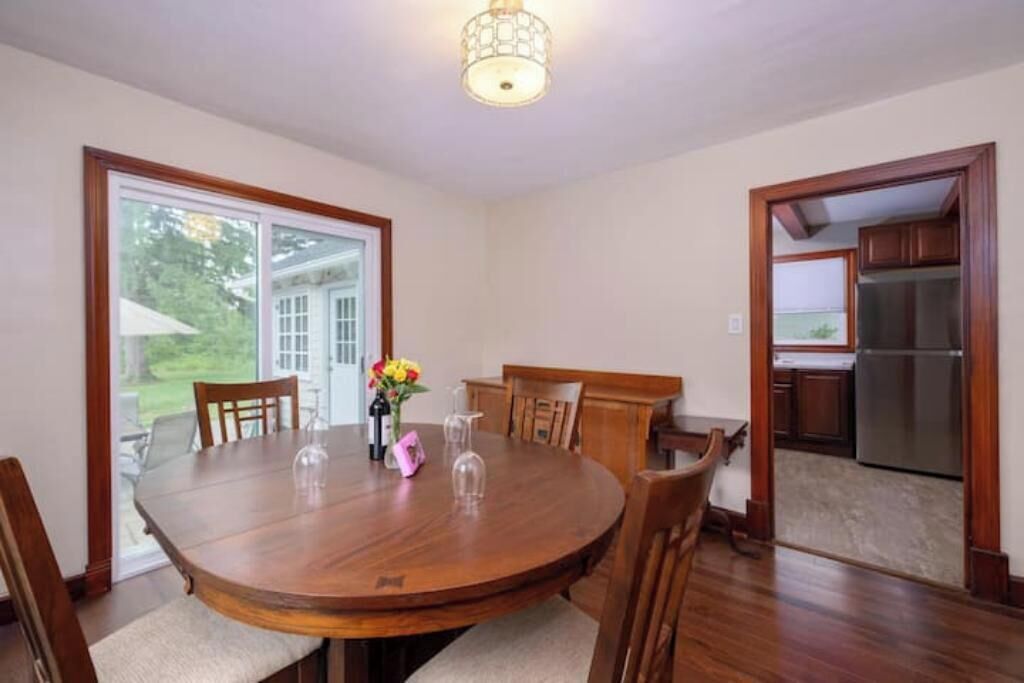 Una sala da pranzo con un tavolo in legno, sedie e un lampadario.