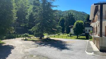 Un estacionamiento con una mesa de picnic y un sendero cercado que conduce a un edificio.