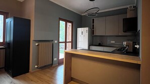 Een moderne keuken met houten vloeren, een inbouwkeukeneiland, een koelkast en een magnetron.