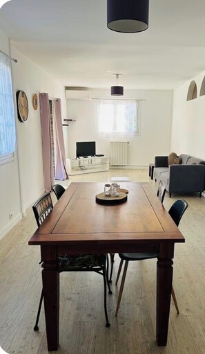A dining area with a wooden table, chairs, and a television in the background. - "The Citrus Nest"   (Lucciana)