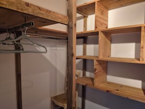 A wooden shelf unit with multiple compartments, a hanging metal rack, and a small stool. - "The Citrus Nest"   (Lucciana)