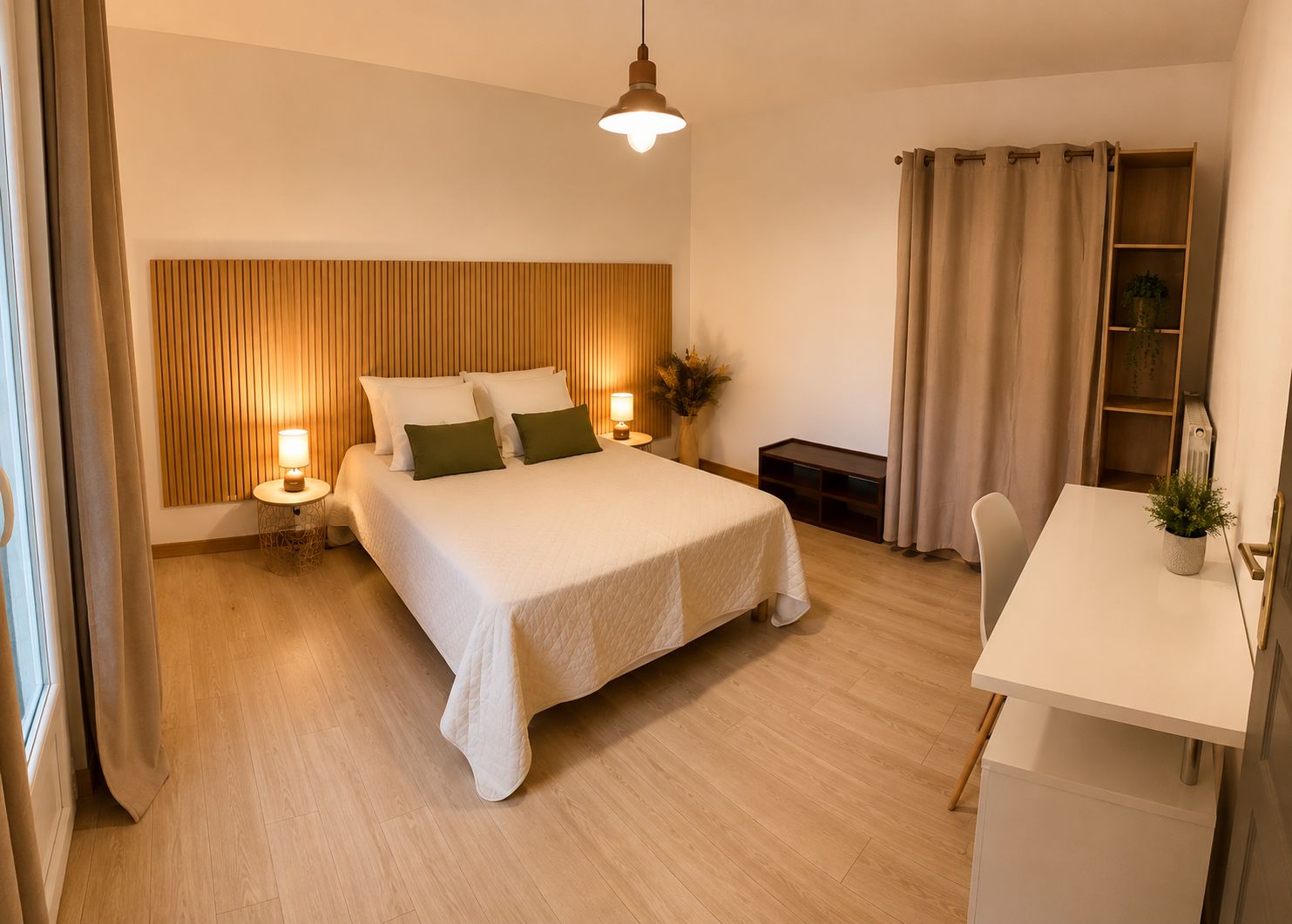 A bedroom with a bed, bedside lamps, a nightstand, a desk, and a potted plant.