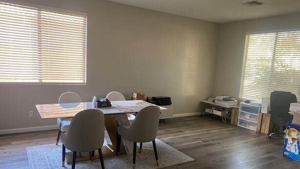 A room with a dining table, chairs, a printer, and storage boxes. - Stunning Avondale Home! (Avondale)
