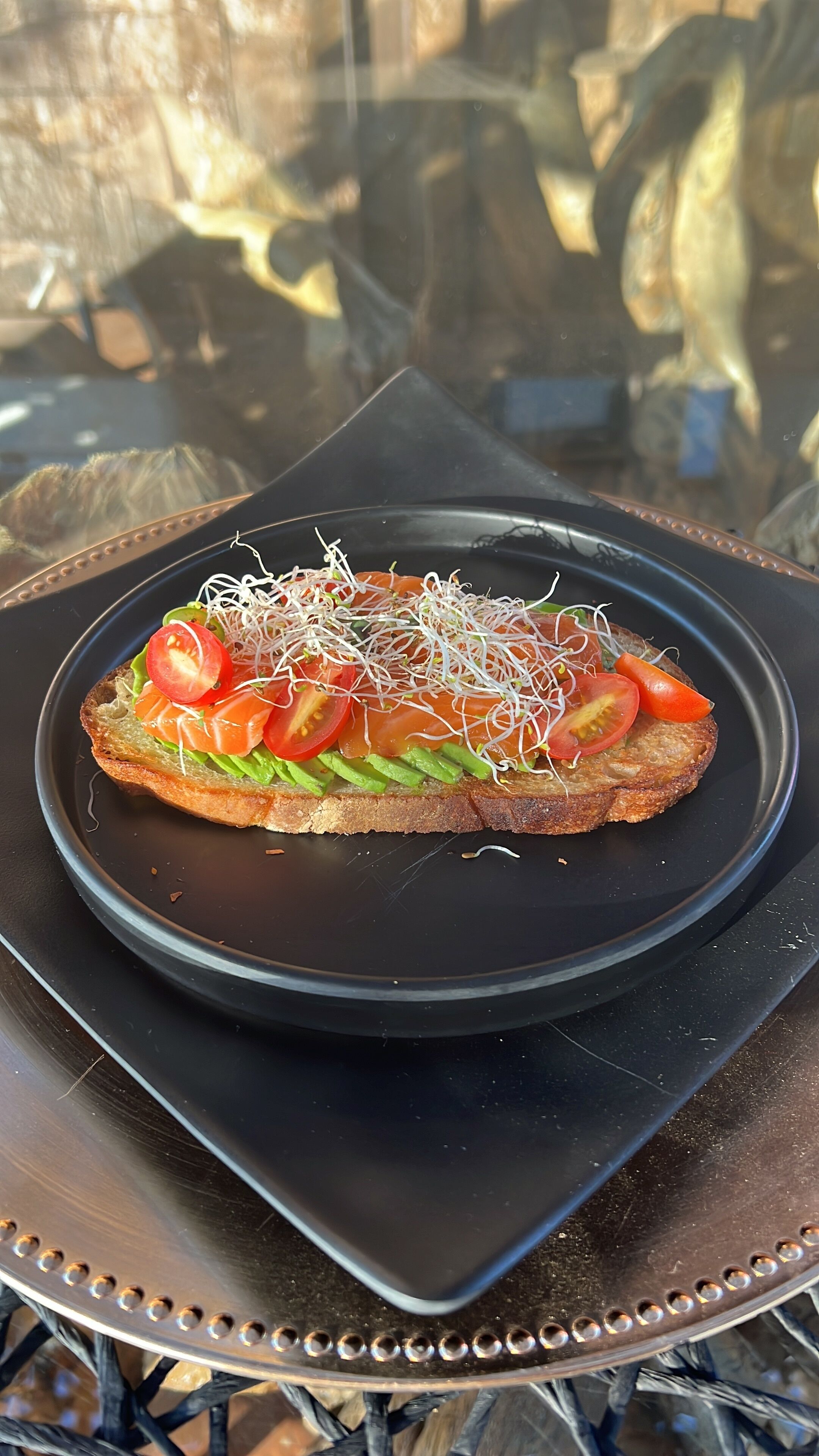 Un panino su un piatto nero su un tavolo.