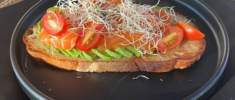 Un panino su un piatto nero su un tavolo.