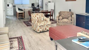 Amplia sala de estar con cocina, comedor y asientos.
