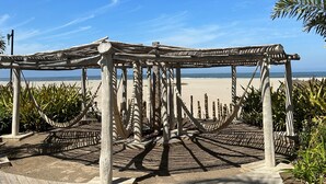 Una estructura de pérgola de madera con vista a la playa y el océano.