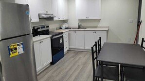 A kitchen with white cabinets, a stainless steel refrigerator, a stove, and a sink. - Brand new 2-bedroom Apartment with  AC/Heat in Brampton (Brampton)