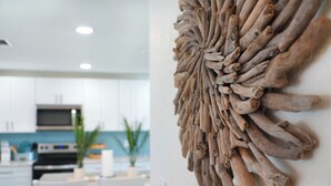 Une cuisine moderne avec des meubles blancs, un four à micro-ondes et un coin repas doté de chaises blanches.