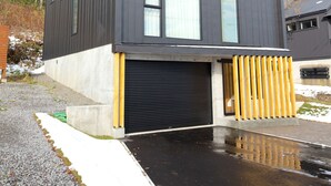 En moderne bygning med to etager, store vinduer og en garageport.