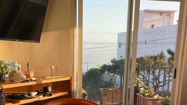 Un comedor con una mesa dispuesta para dos personas, una botella de vino y una cesta de pan.